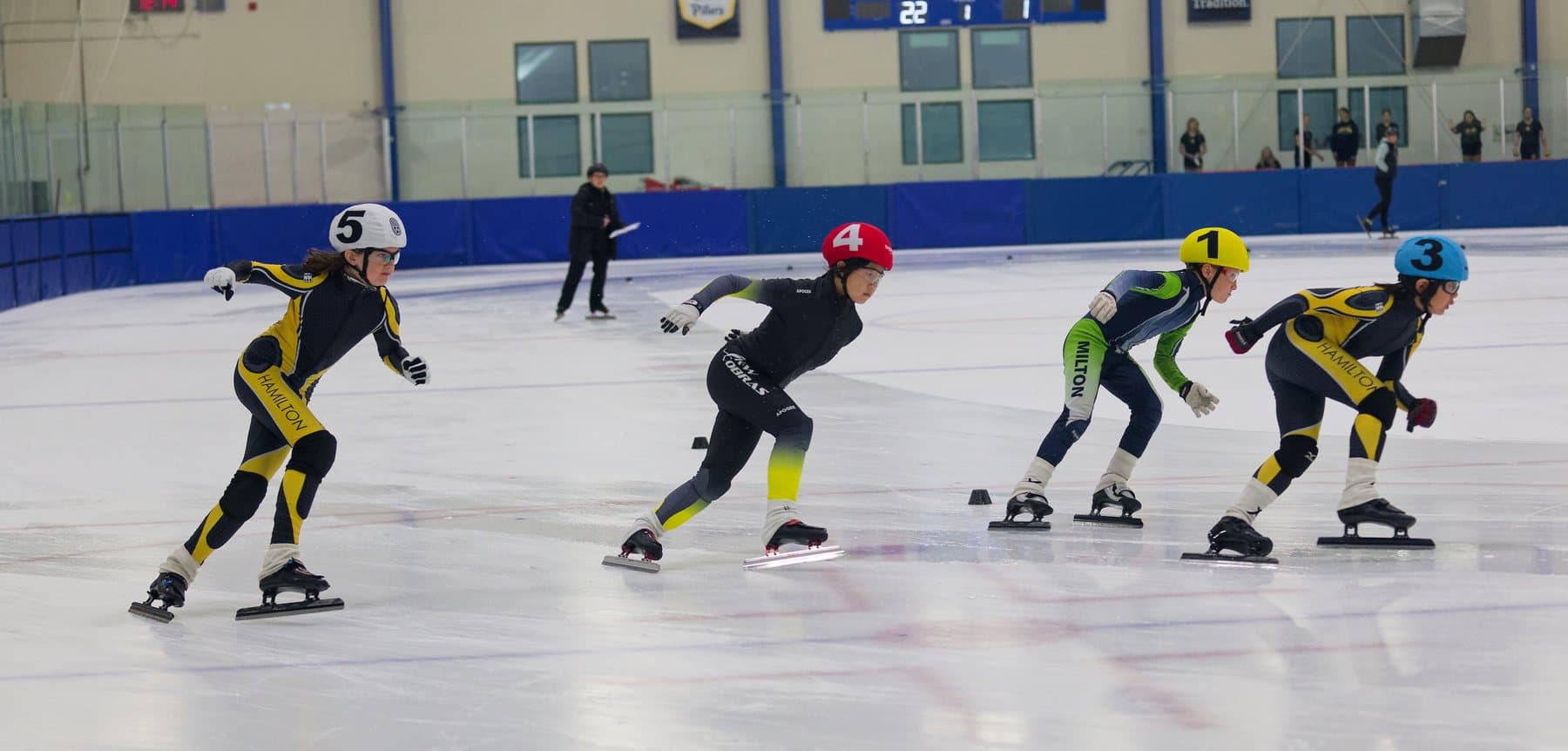 Two Hamilton speed skaters racing a pace line during a short-track meet.
