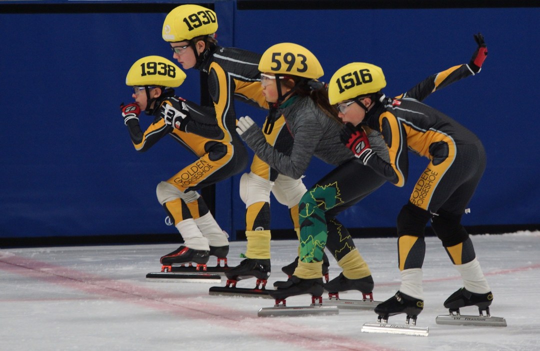Four speed skaters at the starting line.
